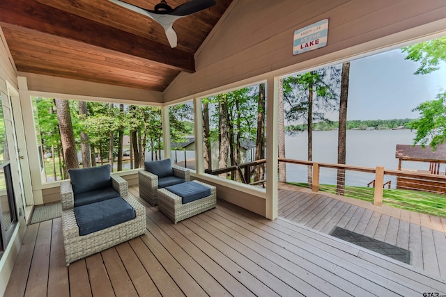 sunroom featuring beamed ceiling, plenty of natural light, a ceiling fan, and a water view