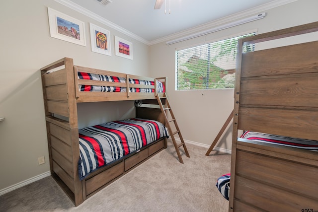 carpeted bedroom with visible vents, a ceiling fan, baseboards, and ornamental molding