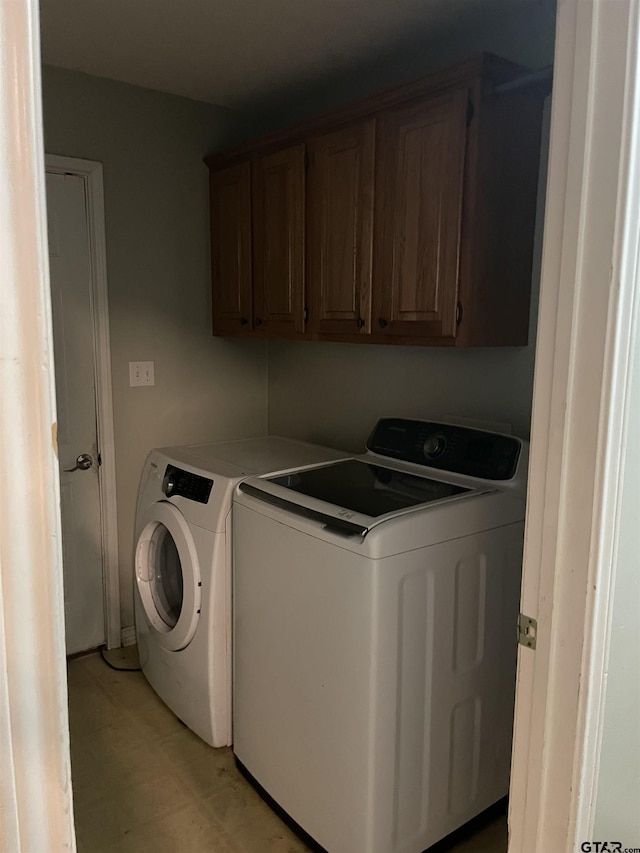 laundry area with cabinets and washing machine and clothes dryer