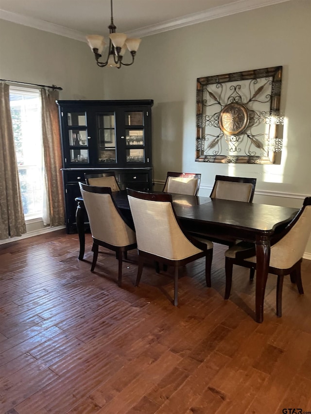 dining area featuring dark hardwood / wood-style flooring, crown molding, and an inviting chandelier