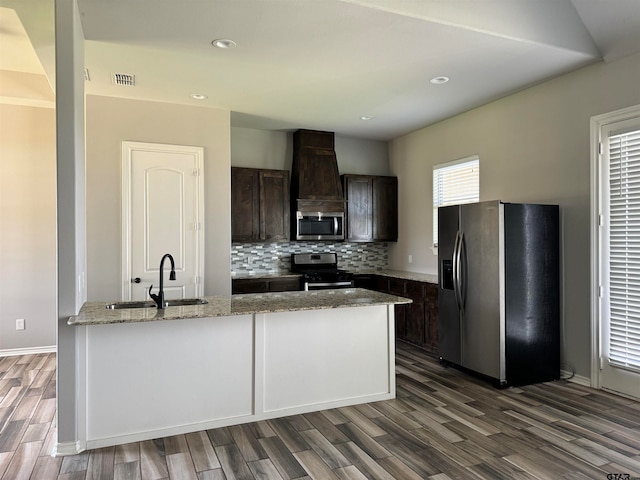 kitchen with stainless steel appliances, dark wood-type flooring, light stone counters, dark brown cabinetry, and sink