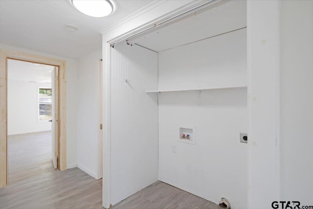 laundry room featuring a textured ceiling, light wood-type flooring, and hookup for a washing machine