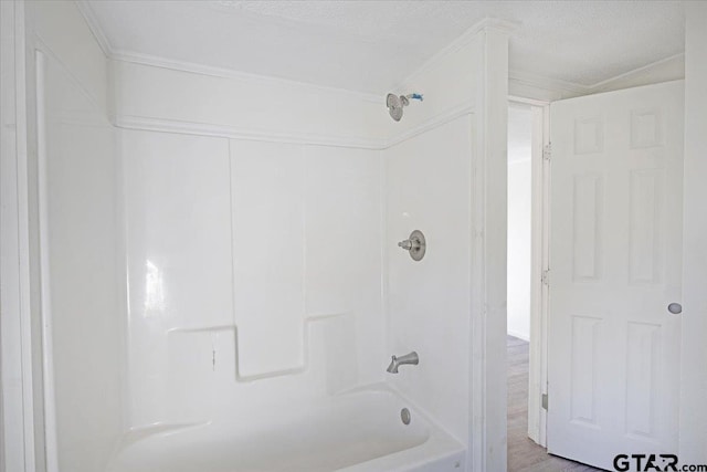 bathroom with wood-type flooring, a textured ceiling, tub / shower combination, and crown molding