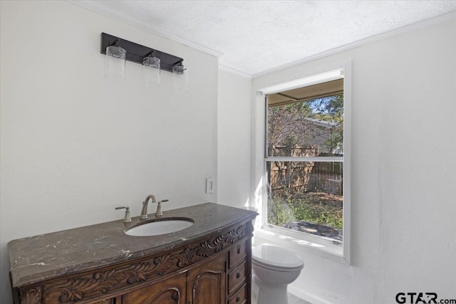 bathroom with ornamental molding, vanity, a textured ceiling, and toilet