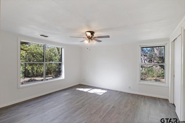 empty room with hardwood / wood-style floors, a textured ceiling, and ceiling fan