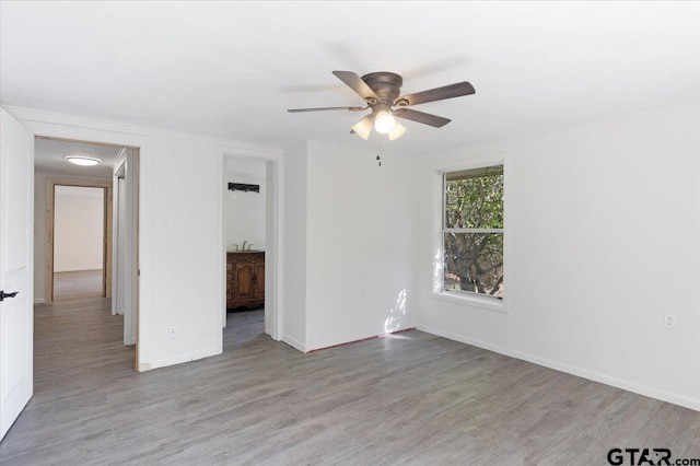 unfurnished room featuring ornamental molding, light wood-type flooring, and ceiling fan