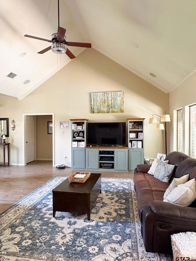 living area with lofted ceiling, ceiling fan, light wood-style flooring, baseboards, and ornamental molding