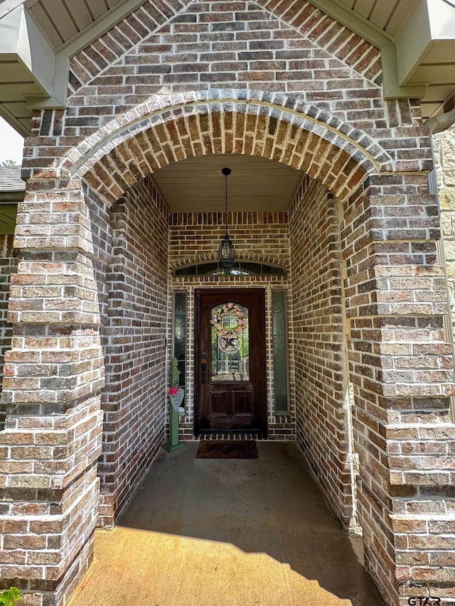 entrance to property featuring brick siding