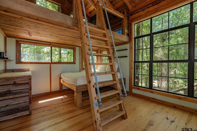 bedroom featuring light hardwood / wood-style flooring, beam ceiling, and wood ceiling