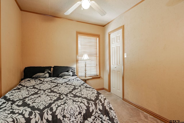 bedroom with a textured ceiling, light carpet, ceiling fan, and crown molding