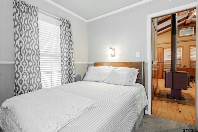 carpeted bedroom with multiple windows, a wood stove, vaulted ceiling, and crown molding