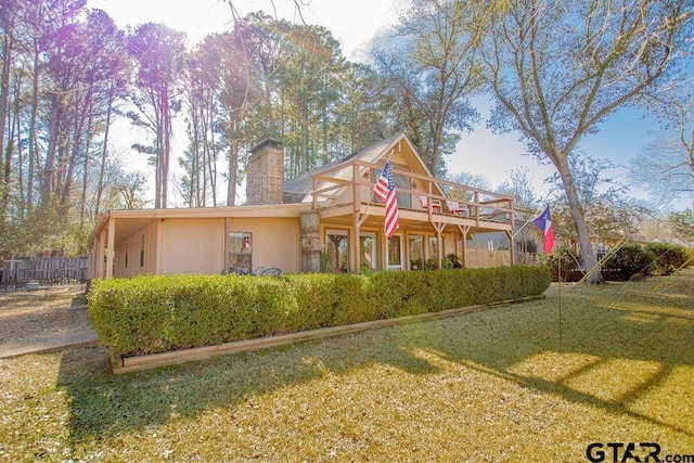 view of front of home with a chimney and a front lawn