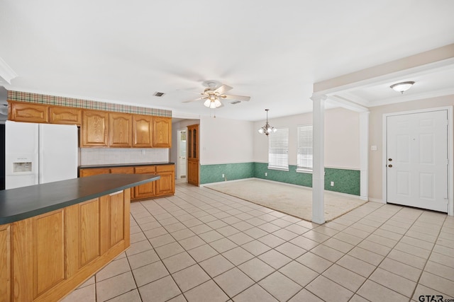 kitchen featuring hanging light fixtures, ceiling fan with notable chandelier, light tile patterned floors, and white fridge with ice dispenser