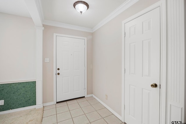 foyer entrance with ornamental molding, light tile patterned flooring, and ornate columns