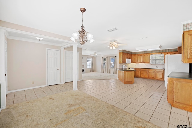 kitchen featuring ceiling fan with notable chandelier, light tile patterned floors, decorative light fixtures, and ornamental molding