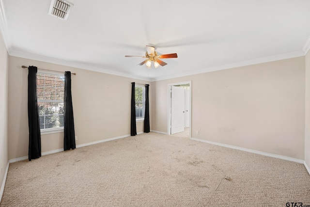 carpeted empty room featuring a wealth of natural light, ceiling fan, and crown molding