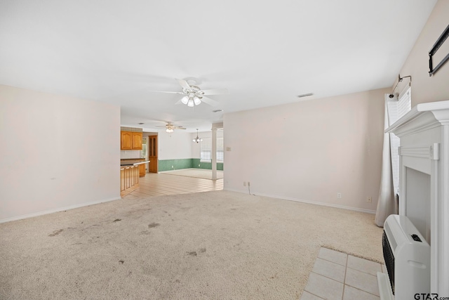 unfurnished living room with light colored carpet and ceiling fan