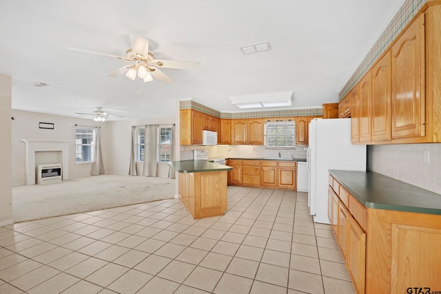 kitchen featuring a kitchen island, a wealth of natural light, white appliances, and ceiling fan