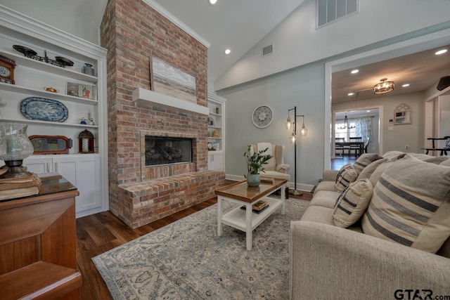 living room with dark wood-type flooring, built in shelves, high vaulted ceiling, and a brick fireplace