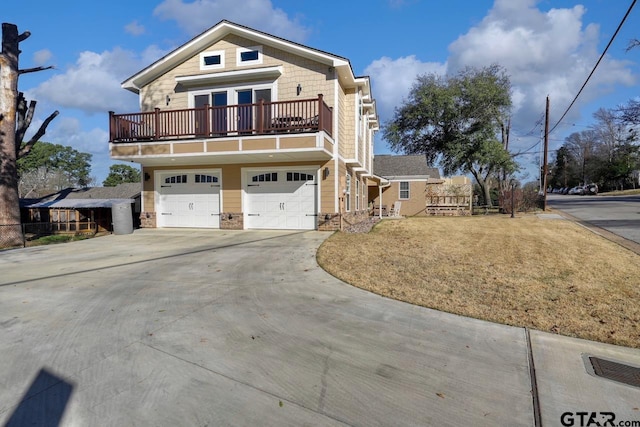 view of front of property with a garage, a balcony, and a front yard