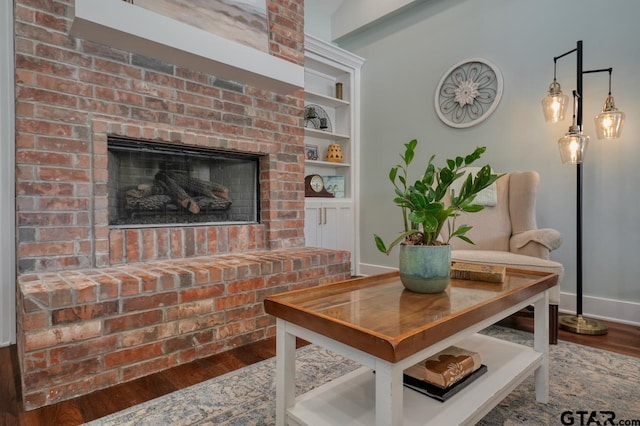 dining space with a brick fireplace, wood-type flooring, and built in features