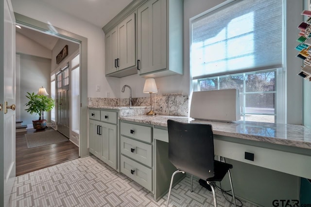 office with sink, built in desk, and light hardwood / wood-style floors