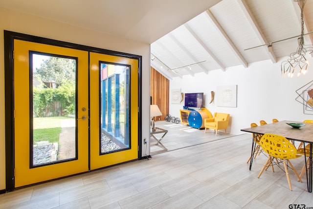 interior space with french doors and vaulted ceiling with beams