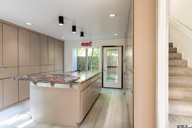 kitchen with light stone counters and a spacious island