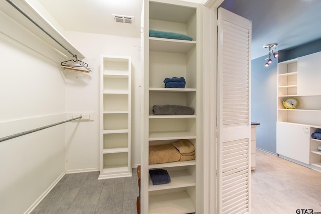 walk in closet with hardwood / wood-style floors