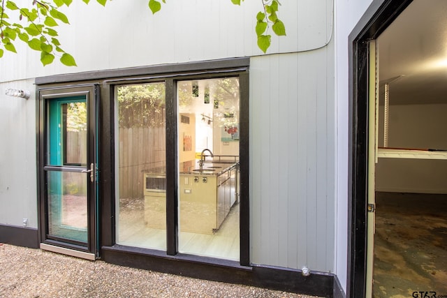 doorway to outside featuring wood walls and sink