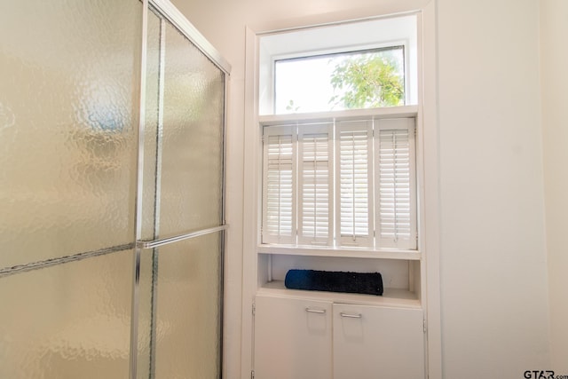 bathroom with a shower with door