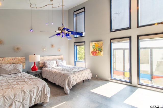 bedroom featuring ceiling fan and a towering ceiling