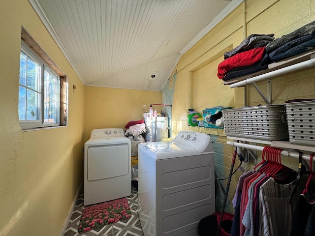 washroom featuring water heater, crown molding, and washer and clothes dryer