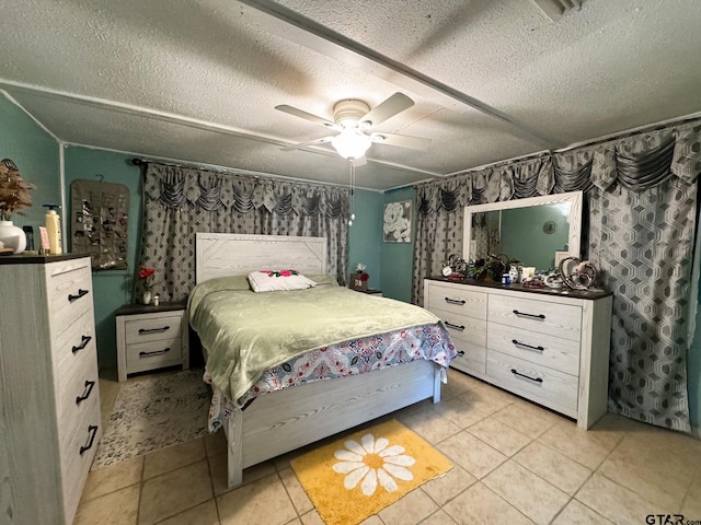 bedroom featuring ceiling fan, a textured ceiling, and light tile patterned floors