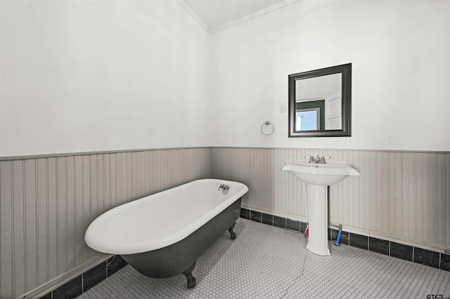 bathroom with a tub, tile patterned flooring, and ornamental molding