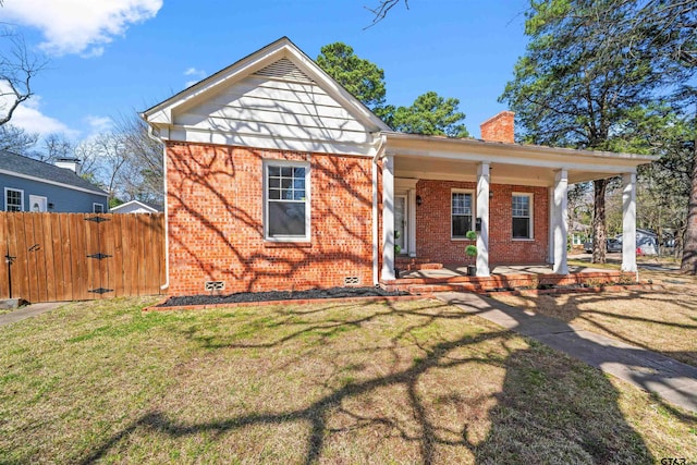 view of front of property featuring a front lawn, fence, crawl space, brick siding, and a chimney