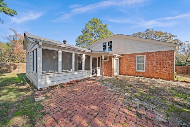 rear view of property featuring a patio and a sunroom