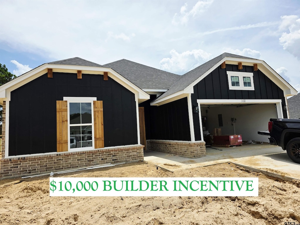 1432 Allison Ln, Lindale, TX 75771 - view of front of home featuring board and batten siding, brick siding, a shingled roof, and a garage
