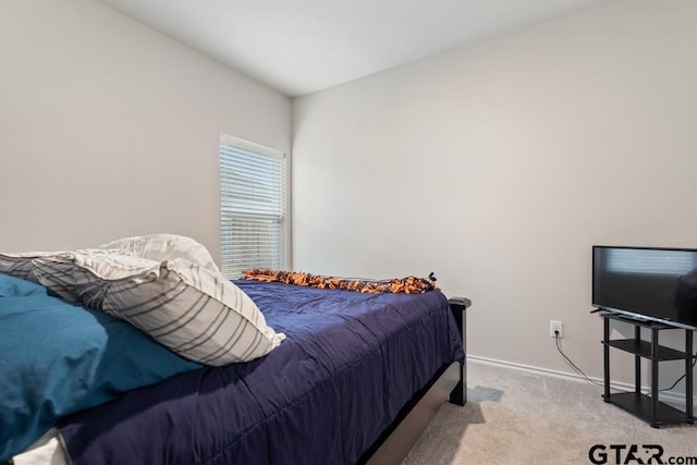 bedroom with light carpet and baseboards