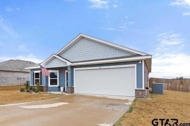 view of front of house with a garage, brick siding, fence, concrete driveway, and a front lawn