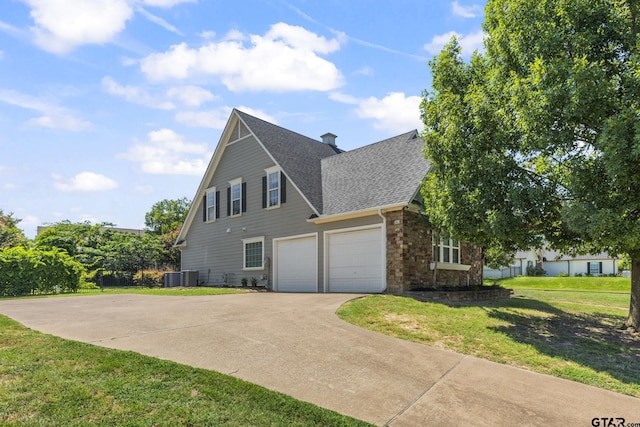 view of side of property featuring central AC, a yard, and a garage