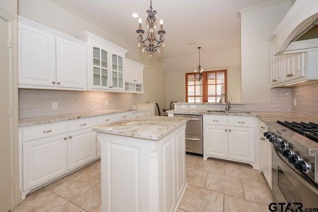 kitchen with pendant lighting, sink, white cabinetry, and premium range hood