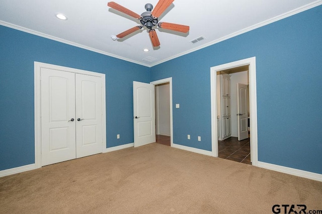 unfurnished bedroom with ceiling fan, a closet, ornamental molding, and carpet