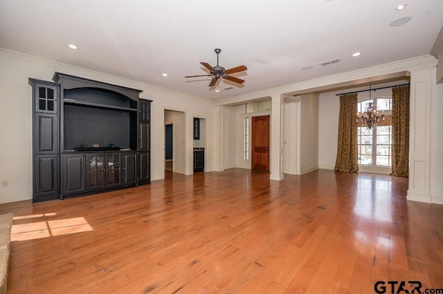 unfurnished living room featuring hardwood / wood-style floors, crown molding, and ceiling fan with notable chandelier