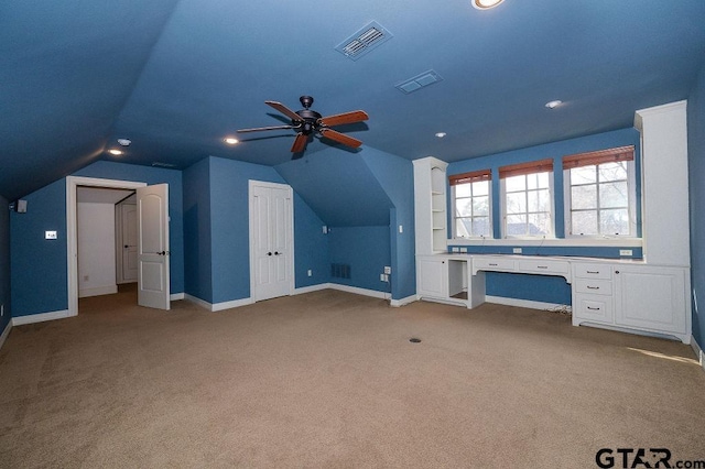 bonus room with lofted ceiling, built in desk, and carpet