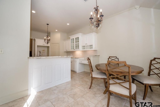 dining room with crown molding, sink, and an inviting chandelier