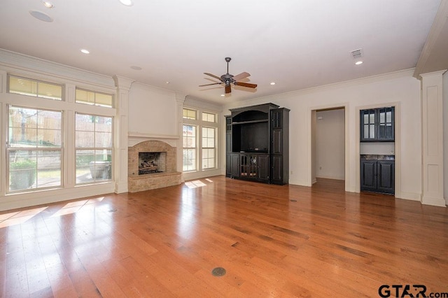 unfurnished living room featuring hardwood / wood-style flooring, ceiling fan, and ornamental molding