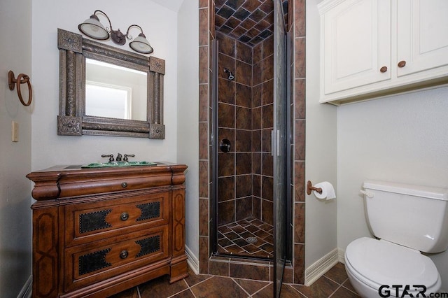 bathroom with vanity, toilet, a shower with shower door, and tile patterned flooring