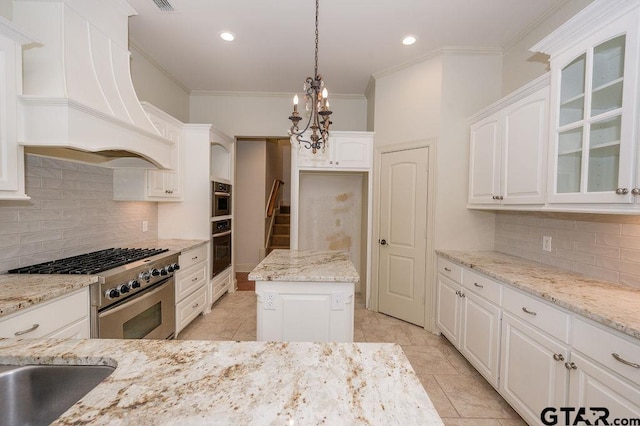 kitchen featuring high end range, light stone countertops, custom range hood, and white cabinets