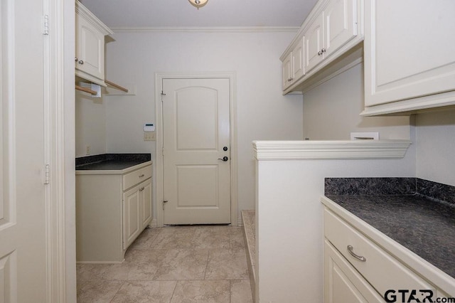 washroom with ornamental molding and cabinets